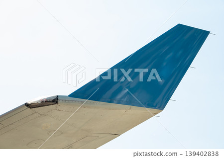 Close-up of blue aircraft winglet with navigation light against sky Close-up of blue aircraft winglet with navigation light against sky 139402838