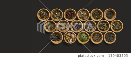 Elegant presentation of assorted dried herbs in textured wooden bowls with minimalistic background 139403503