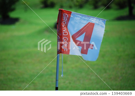 A red flag number four is erected on the grass. A red flag number four is erected on the grass. 139403669