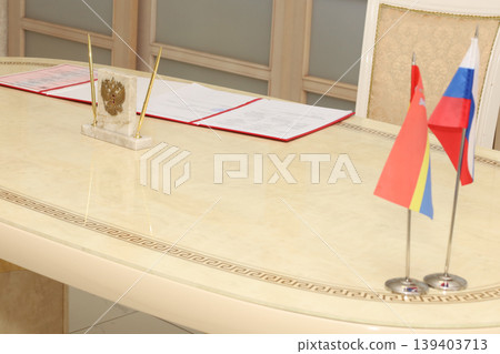 Polished table holds official documents and national flags 139403713