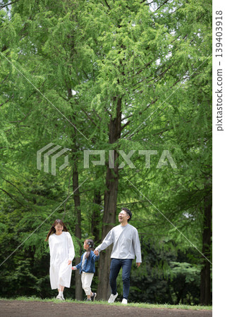 幸福的家庭生活：手牽手漫步在綠樹環繞的公園。 （全身豎幅） 139403918