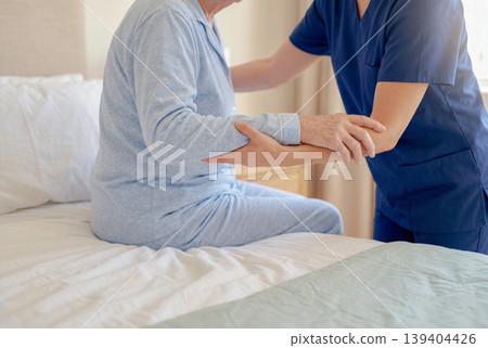 護理人員扶著臥床的老人。 139404426