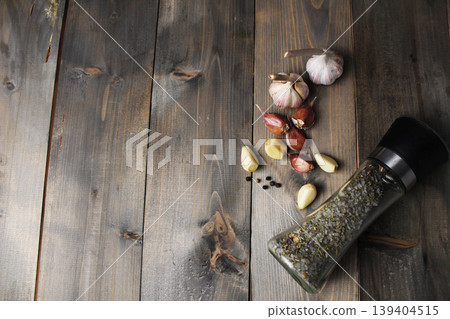 Peeled garlic cloves and salt in a salt shaker on a grey background. Peeled garlic cloves and salt in a salt shaker on a grey background. 139404515