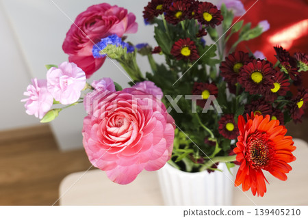 Vase of colorful flowers with a red heart balloon in the background, creating a bright Mothers Day composition. 139405210