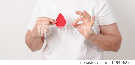 Elderly woman with red Blood drop paper for concept of June World Blood Donor day, Donation, April Hemophilia awareness day, May Thalassemia Day, Anemia awareness, June Sickle Cell and Blood Disorders Elderly woman with red Blood drop paper for concept of June World Blood Donor day, Donation, April Hemophilia awareness day, May Thalassemia Day, Anemia awareness, June Sickle Cell and Blood Disorders 139406253