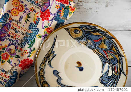 Okinawan traditional crafts: Yachimun pottery with fish pattern plate and Bingata cloth. Okinawan traditional crafts: Yachimun pottery with fish pattern plate and Bingata cloth. 139407091