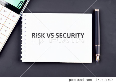 The phrase RISK VS SECURITY appears on a white spiral notebook, centrally placed on a dark surface alongside a professional calculator and an elegant black pen The phrase RISK VS SECURITY appears on a white spiral notebook, centrally placed on a dark surface alongside a professional calculator and an elegant black pen 139407302