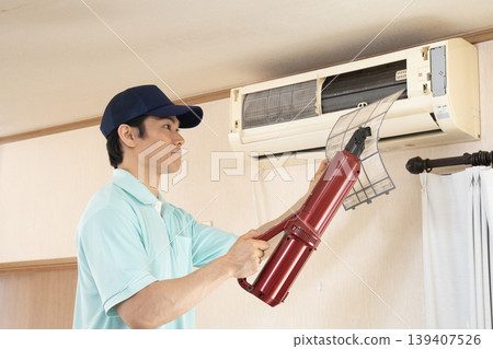 Worker cleaning air conditioner filters Worker cleaning air conditioner filters 139407526