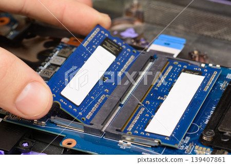 Installing new RAM memory chips to the laptop. Repairing and upgrading laptop at home Installing new RAM memory chips to the laptop. Repairing and upgrading laptop at home 139407861