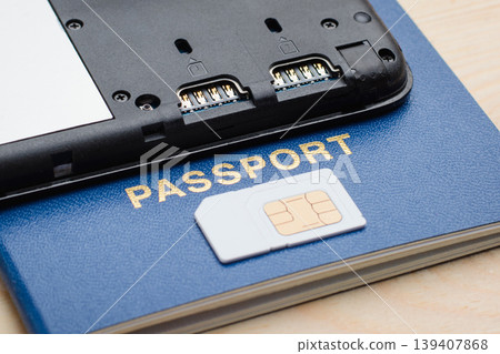 Modern mobile phone on a passport near a SIM card. Registration and identification SIM card for mobile phone using passport Modern mobile phone on a passport near a SIM card. Registration and identification SIM card for mobile phone using passport 139407868