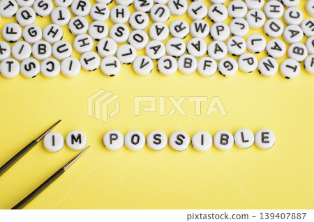 Tweezers removes letters I and M of the word IMPOSSIBLE and makes word POSSIBLE. Word POSSIBLE made of white yellow plastic blocks on yellow background Tweezers removes letters I and M of the word IMPOSSIBLE and makes word POSSIBLE. Word POSSIBLE made of white yellow plastic blocks on yellow background 139407887