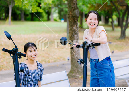 女大學生與朋友一起騎電動滑板 139408317