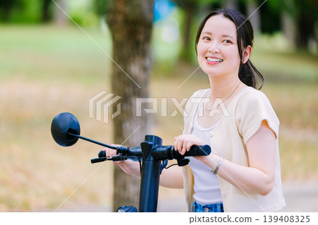一位年輕女子騎著電動滑板車 139408325