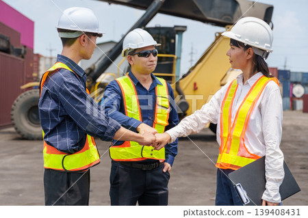 Diverse mid-adult Asian shipping workers stack hands in a show of partnership and unity at a Thai logistics yard Diverse mid-adult Asian shipping workers stack hands in a show of partnership and unity at a Thai logistics yard 139408431