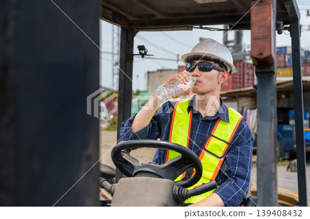 Asian Male Forklift Operator 20-30s Drinking Water at Logistics Site Asian Male Forklift Operator 20-30s Drinking Water at Logistics Site 139408432
