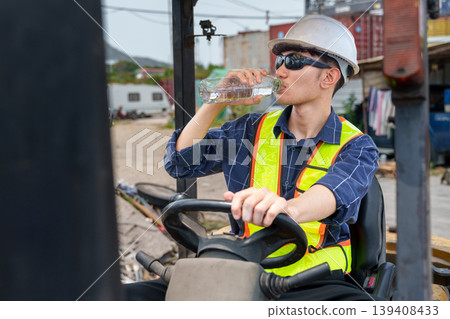 Asian Male Forklift Operator 20-30s Drinking Water at Logistics Site 139408433