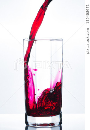 Pouring red juice in glass with bubbles  139408671