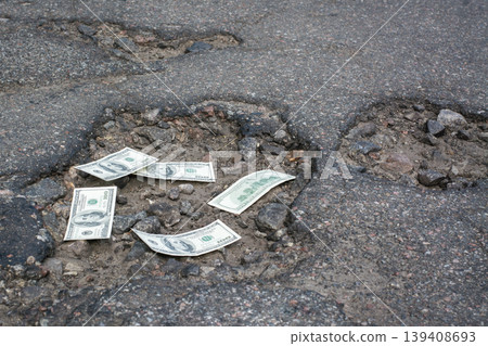 Dollar bills in the potholes on road Dollar bills in the potholes on road 139408693