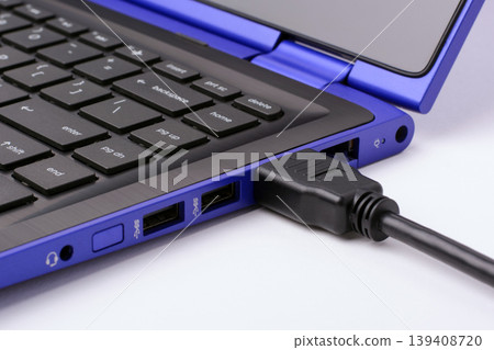 HDMI cable plugged in the modern blue laptop on a white background HDMI cable plugged in the modern blue laptop on a white background 139408720