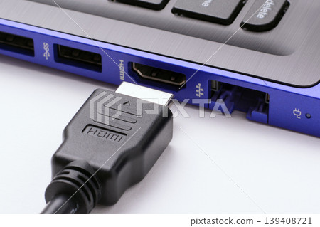 HDMI cable near the HDMI port of the modern blue laptop on a white background HDMI cable near the HDMI port of the modern blue laptop on a white background 139408721