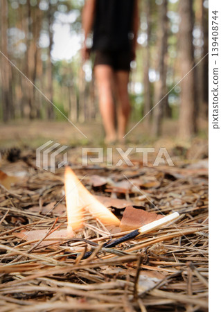 A man left a burning match in a forest. Burning fire in a forest may cause forest fire. A man left a burning match in a forest. Burning fire in a forest may cause forest fire. 139408744