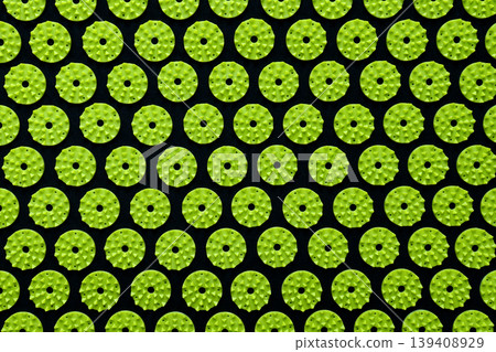 Abstract background of green acupressure massage mat spikes on a black fabric base Abstract background of green acupressure massage mat spikes on a black fabric base 139408929