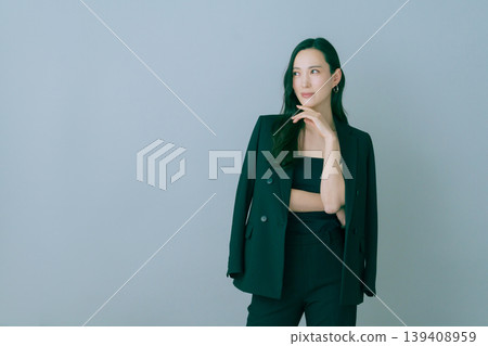 Fashion portrait of a young Japanese woman in a black suit on a gray background Fashion portrait of a young Japanese woman in a black suit on a gray background 139408959