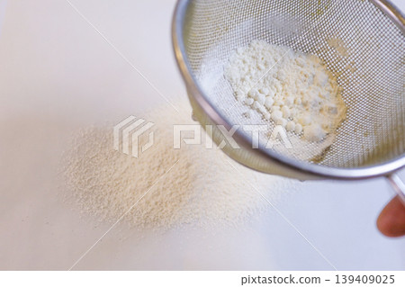 Making custard cream: Sifting flour Making custard cream: Sifting flour 139409025