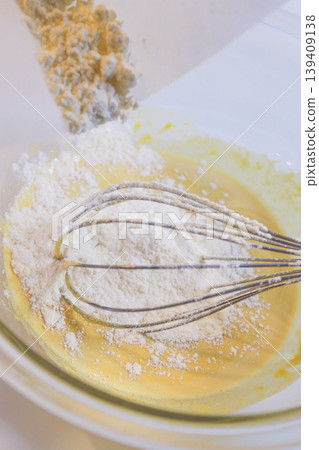 Making custard cream: The process of adding flour to eggs and sugar and mixing. Making custard cream: The process of adding flour to eggs and sugar and mixing. 139409138