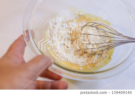 製作蛋奶糊:將麵粉加入雞蛋和糖中攪拌的過程。 製作蛋奶糊:將麵粉加入雞蛋和糖中攪拌的過程。 139409140