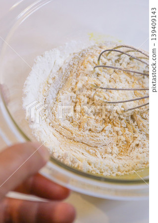製作蛋奶糊:將麵粉加入雞蛋和糖中攪拌的過程。 製作蛋奶糊:將麵粉加入雞蛋和糖中攪拌的過程。 139409143
