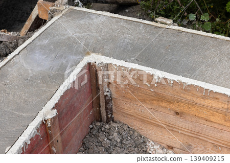 Corner of a concrete footing and wooden formwork on residential construction site Corner of a concrete footing and wooden formwork on residential construction site 139409215