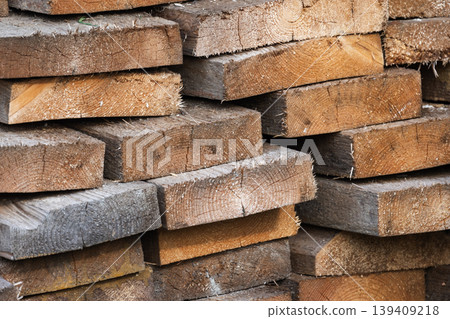 Stacked rough-cut lumber and sawn timber planks showing wood grain 139409218