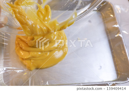 Transferring custard cream to a tray (homemade confectionery) Transferring custard cream to a tray (homemade confectionery) 139409414