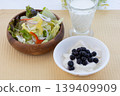 A healthy breakfast of yogurt and milk topped with salad and blueberries. 139409909