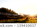 The SL Banetsu Monogatari train runs bathed in the setting sun. 139410037