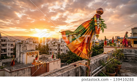 Traditional Gudi on roof terrace moving in gentle breeze at sunrise. Representation of Hindu New Year and peaceful festive atmosphere. Traditional Gudi on roof terrace moving in gentle breeze at sunrise. Representation of Hindu New Year and peaceful festive atmosphere. 139410288