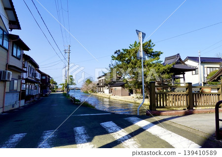 A view of the merchant houses and townscape along the Kumihama coast, seen from the foot of the bridge over the Kumitani River in Kumihama Bay, Kumihama-cho, Kyotango City, Kyoto Prefecture. A view of the merchant houses and townscape along the Kumihama coast, seen from the foot of the bridge over the Kumitani River in Kumihama Bay, Kumihama-cho, Kyotango City, Kyoto Prefecture. 139410589