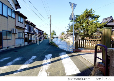 A view of the merchant houses and townscape along the Kumihama coast, seen from the foot of the bridge over the Kumitani River in Kumihama Bay, Kumihama-cho, Kyotango City, Kyoto Prefecture. A view of the merchant houses and townscape along the Kumihama coast, seen from the foot of the bridge over the Kumitani River in Kumihama Bay, Kumihama-cho, Kyotango City, Kyoto Prefecture. 139410590