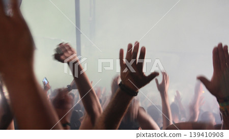 Raised hands of crowd at football stadium cheering team, emotional fans moment, sports passion, unity feeling, live event energy. Raised hands of crowd at football stadium cheering team, emotional fans moment, sports passion, unity feeling, live event energy. 139410908