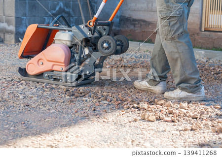 Heavy compaction equipment in action during ground preparation. The process improves stability and prevents future surface deformation. 139411268
