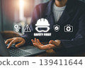 Business professional at a desk with safety icons overlay, emphasizing workplace safety and health measures. 139411644