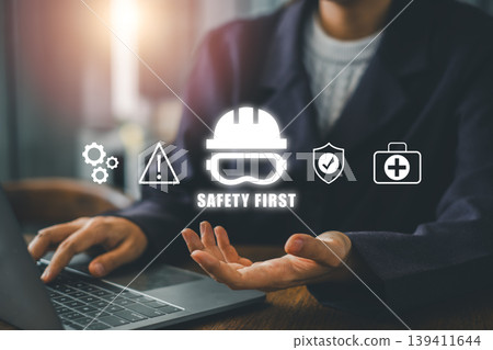 Business professional at a desk with safety icons overlay, emphasizing workplace safety and health measures. Business professional at a desk with safety icons overlay, emphasizing workplace safety and health measures. 139411644