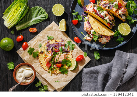 salmon tacos drizzled with sauce on a plate 139412341