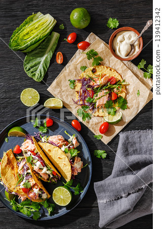salmon tacos drizzled with sauce on a plate salmon tacos drizzled with sauce on a plate 139412342
