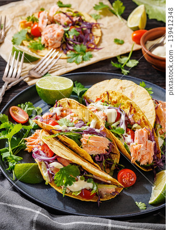 salmon tacos drizzled with sauce on a plate salmon tacos drizzled with sauce on a plate 139412348