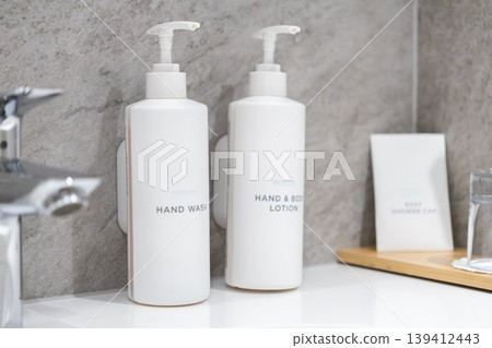 Modern white pump dispenser bottles of hand wash and body lotion provide essential hygiene amenities for personal self-care in a clean, contemporary bathroom setting Modern white pump dispenser bottles of hand wash and body lotion provide essential hygiene amenities for personal self-care in a clean, contemporary bathroom setting 139412443