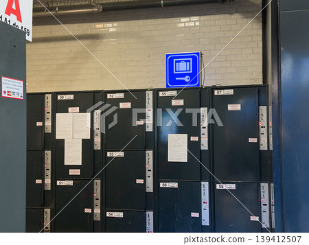 Public storage lockers with numbered doors and an illuminated luggage key sign, providing convenient temporary self-service for travelers in a transport terminal Public storage lockers with numbered doors and an illuminated luggage key sign, providing convenient temporary self-service for travelers in a transport terminal 139412507