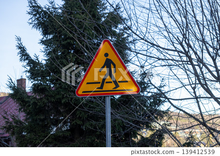 Vibrant yellow triangular pedestrian crossing sign alerts drivers about upcoming crosswalks, promoting essential road safety, traffic awareness, and pedestrian protection Vibrant yellow triangular pedestrian crossing sign alerts drivers about upcoming crosswalks, promoting essential road safety, traffic awareness, and pedestrian protection 139412539