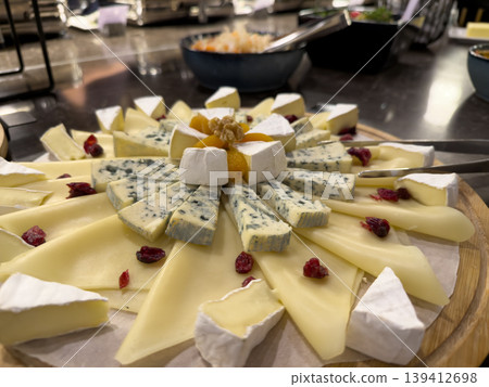 Gourmet cheese platter showcasing a variety of blue, soft, and hard cheeses, garnished with dried fruit and nut for a catering event Gourmet cheese platter showcasing a variety of blue, soft, and hard cheeses, garnished with dried fruit and nut for a catering event 139412698